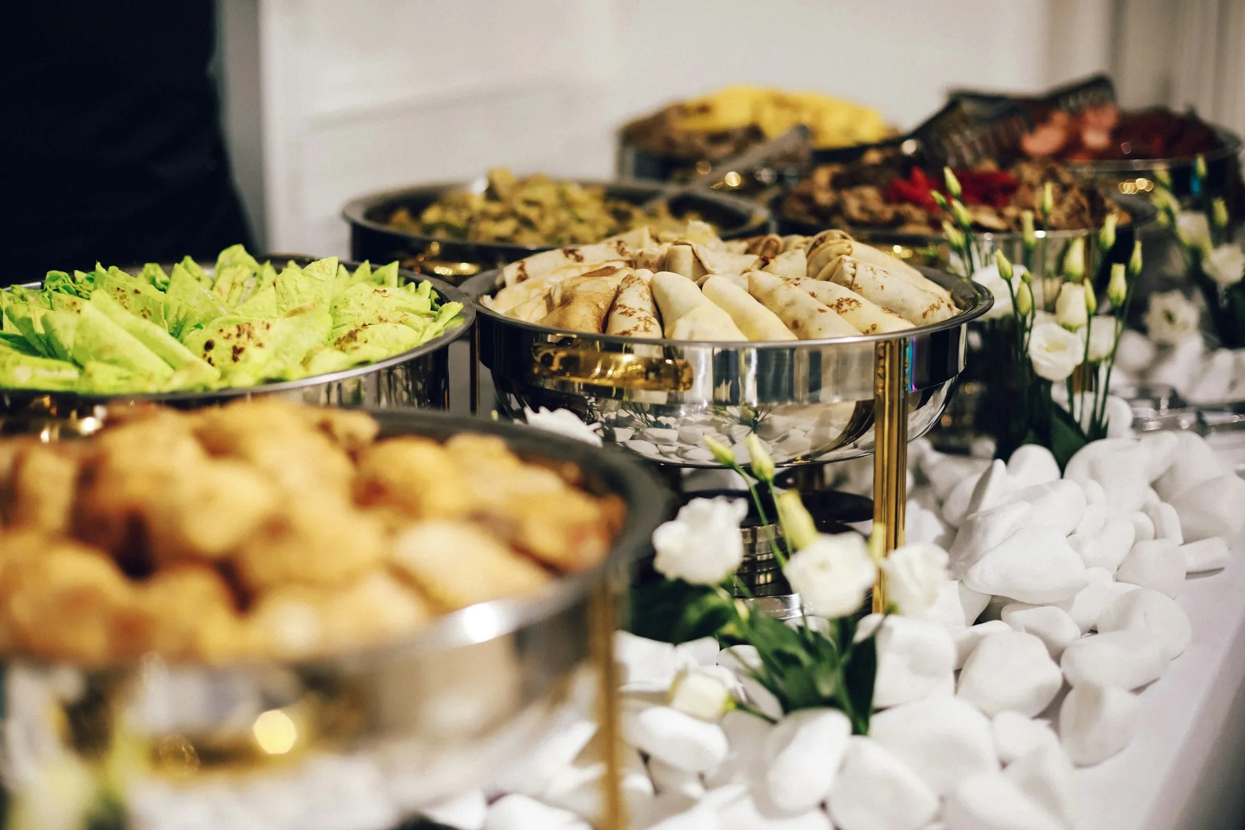 Chauffe-plats en inox alignés sur une table de buffet