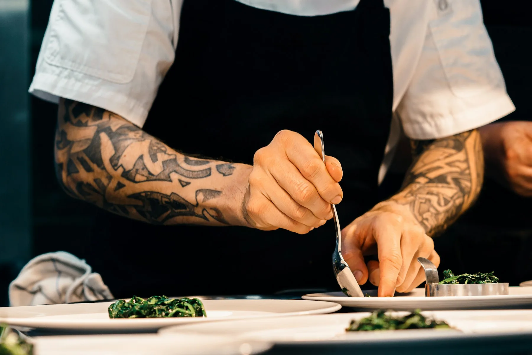 Mains dressant une assiette en cuisine