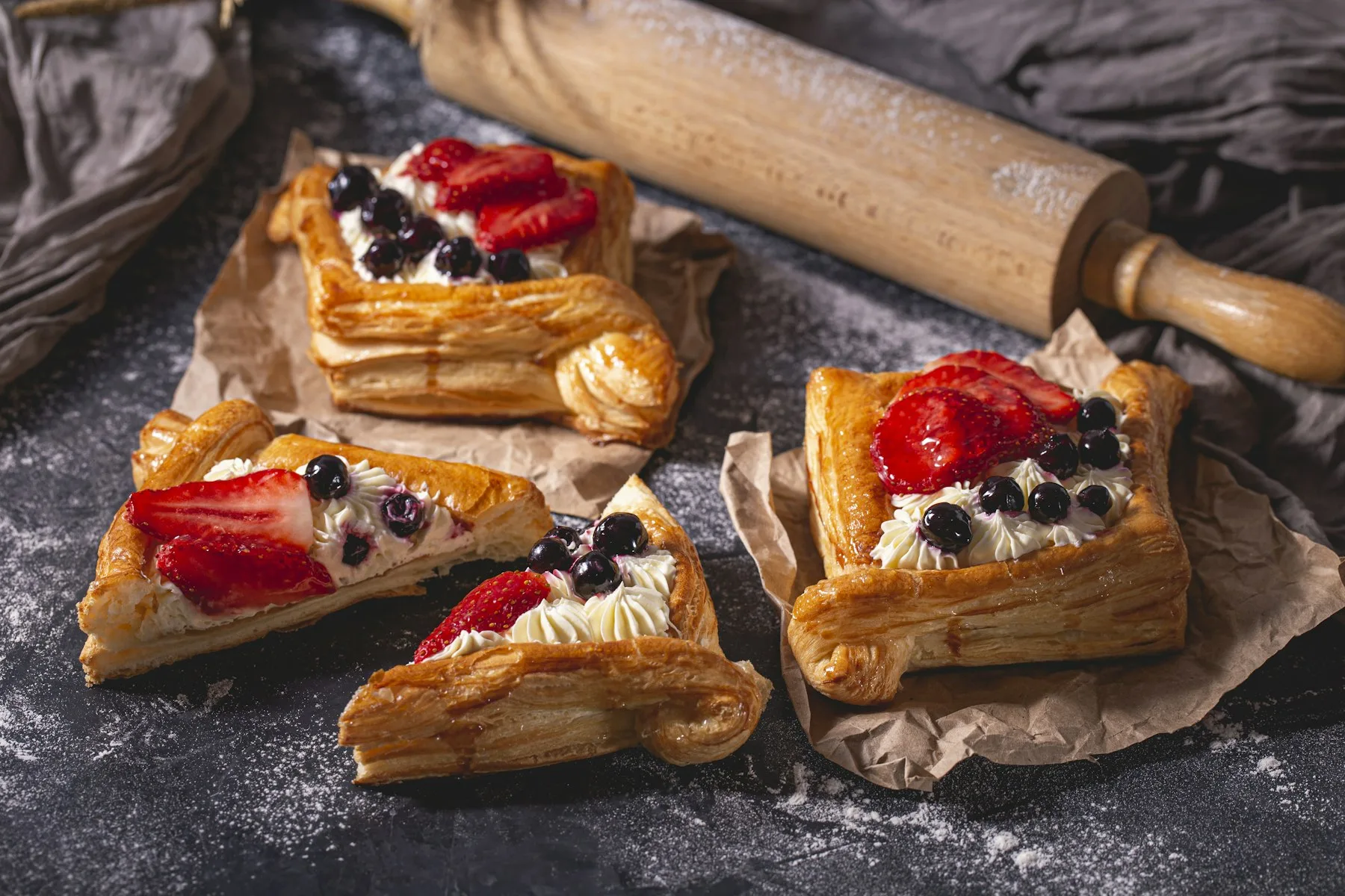 Quatre pâtisseries garnies de fraises et de myrtilles