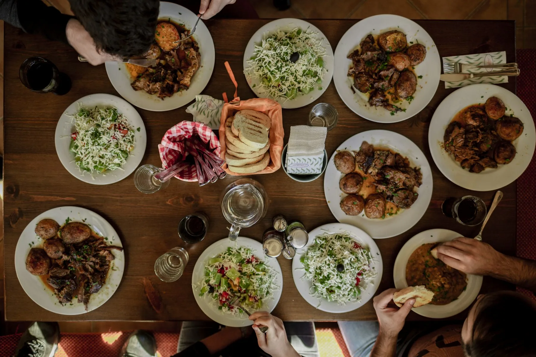 Assiettes blanches garnies de plats variés sur une table partagée
