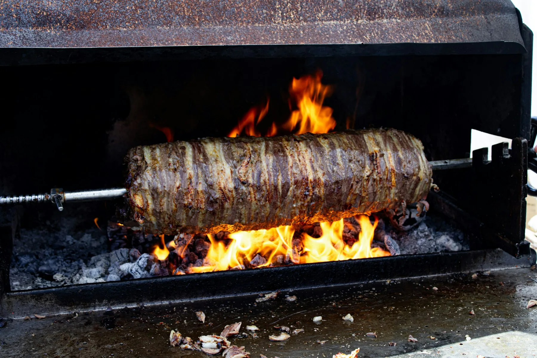 Viande rôtie à la broche au-dessus d'un feu de bois
